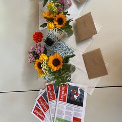 Blumensträuße, Umschläge und Flyer dekorieren die Tische beim Lesefest.